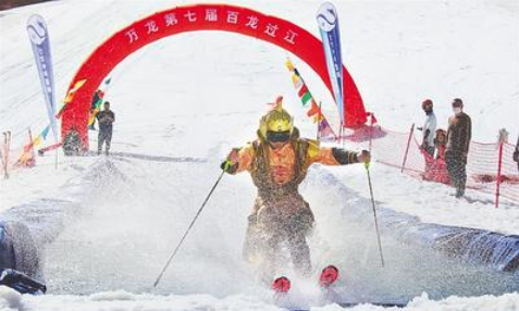 5月1日，万龙滑雪场第七届“百龙过江”活动现场，一名选手滑过水池。