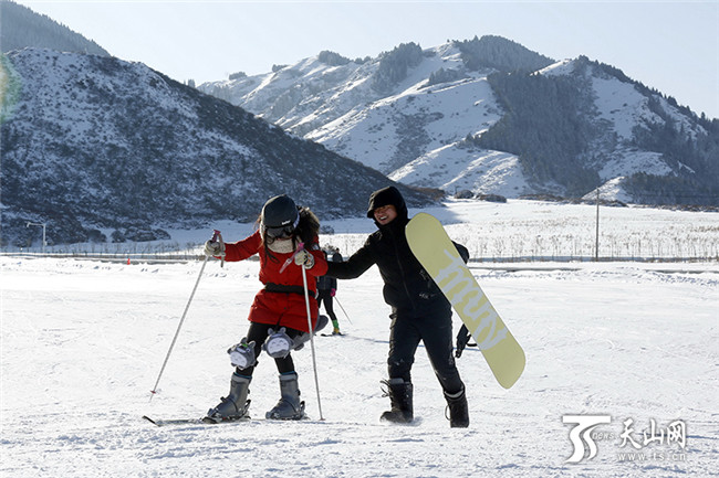 在白云国际滑雪场内，一位初学者在同伴的搀扶下学习滑雪。